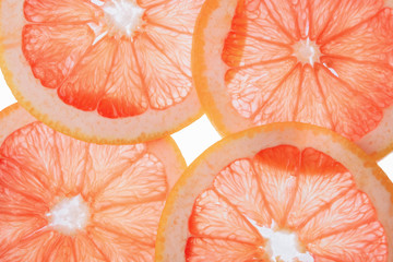 translucent grapefruit slices on a white background, citrus fruit slices