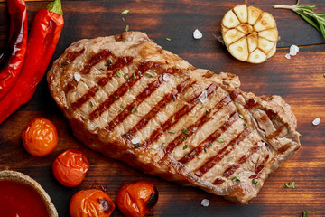 Whole beef steak, fried striploin on wooden cutting board. Keto ketogenic diet. Close up, top view