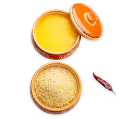 Homemade ghee, rice in a ceramic pot and red peppers. Isolated white background.