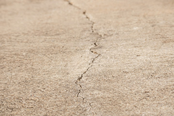 A cracks on the concrete floor. Surface of concrete covered with cracks,close up of crack cement road,concrete texture closeup background.