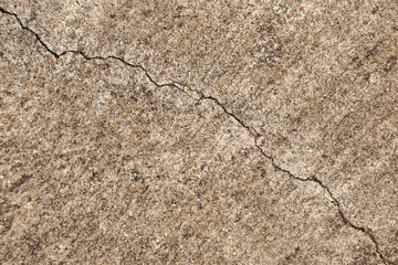 A cracks on the concrete floor. Surface of concrete covered with cracks,close up of crack cement road,concrete texture closeup background.