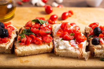 Mix of bruschette with cherry tomatoes and cream cheese, hummus and black olives. Italian food, healthy appetizer