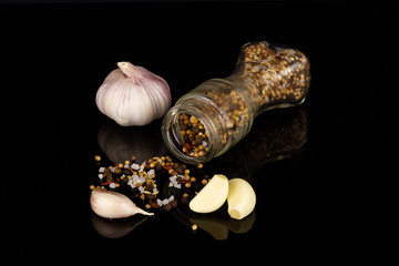 head and cloves of fresh garlic on a black mirror surface with reflection
