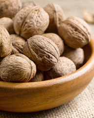 Vertical closeup nuts in a wooden plate