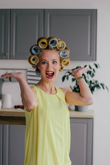 Girl blonde in curlers and in a yellow dress smiling