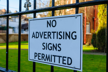 Fototapeta premium Sign on a fence warning that advertising signs are not permitted