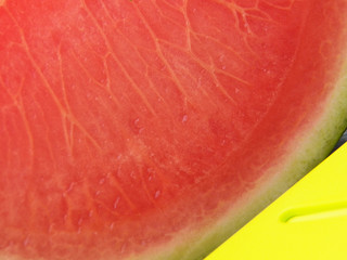 A large wartermelon fruit with texture details section and a yellow giant knife close-up. Fruit and...