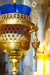Church lamp in front of the icon. A burning lamp, a candle in a blue flask sways in front of the...