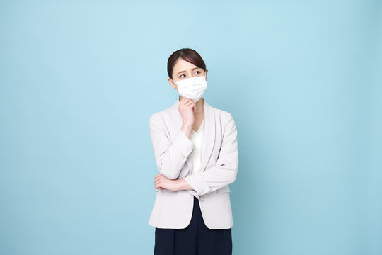 マスクをしながら腕を組んでいる女性