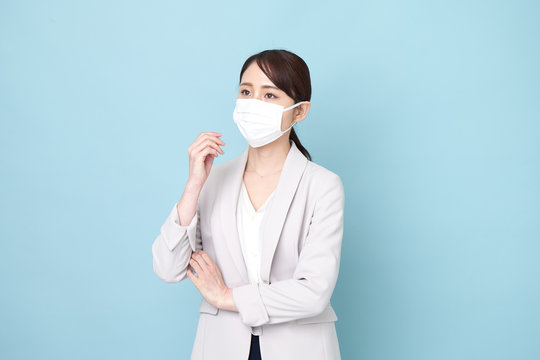 マスクをしながら腕を組んでいる女性