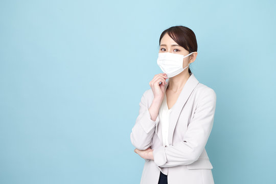 マスクをしながら腕を組んでいる女性