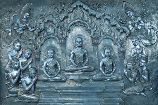Buddha life scenes on carved metal at the temple in Thailand.