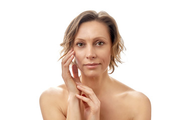 Beautiful young woman with a short haircut is touching her face skin. Clean skin. Naked to the shoulders posing. isolated white background.