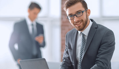 Handsome businessman is working with laptop in office
