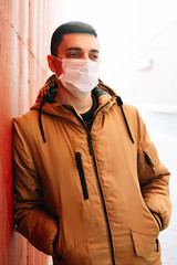 a young man in a brown jacket with a medical mask on his face, fighting against the corona 19 virus...
