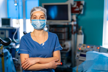 Fototapeta na wymiar Portrait of young surgical nurse in sterile glove standing in operating theatre. Portrait of femaledoctor in protective mask.