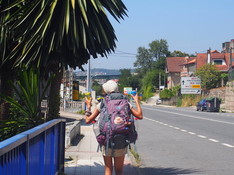 Pilgrim walking while peace sign, Camino de Santiago, Way of St. James, Journey from Valenca to Cesantes, Portuguese way, Portugal