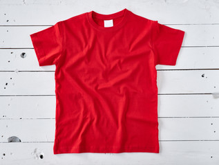 Red t-shirt on white wooden background