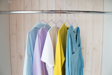 spring-summer wardrobe. multi-colored clothes on a hanger in a closet. quarantine, leisure activities