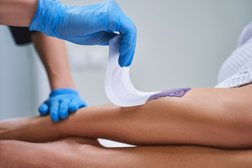 Cosmetologist doing waxing for woman stock photo