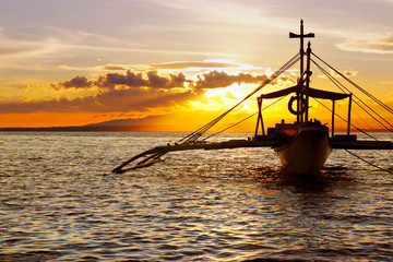 Fototapeta na wymiar silhouette of boat on the beach during sunset in philippines 