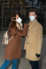Caucasian couple wearing masks and black nitrile gloves walking on street Selective focus