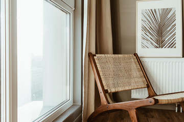 Modern interior design concept. Stylish rattan wooden chair, window, curtains. Minimal comfortable...