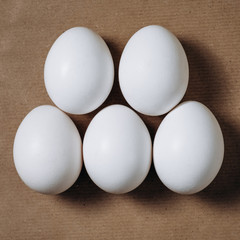 five white eggs on craft paper background