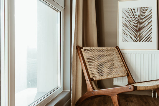 Modern interior design concept. Stylish rattan wooden chair, window, curtains. Minimal comfortable cozy living room.