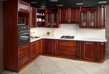 Interior of modern kitchen in classic style with golden elements cherry alder wood cabinetry with...
