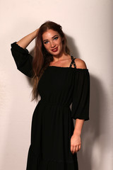 Fototapeta premium Beautiful woman in black dress on bright background