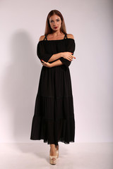 Fototapeta premium Beautiful woman in black dress on bright background