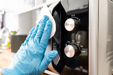 Man Wiping Microwave Oven Handle With Sanitizer