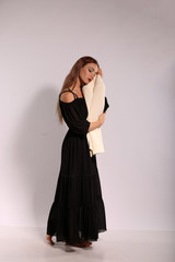 Fototapeta premium Beautiful woman in black dress on bright background