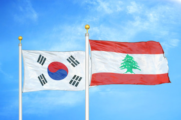 South Korea and Lebanon two flags on flagpoles and blue cloudy sky
