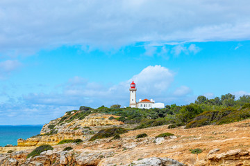 Fototapeta na wymiar famous historic lighthouse of Carvoeiro at the wild coast of the Algarve at Carvoeiro