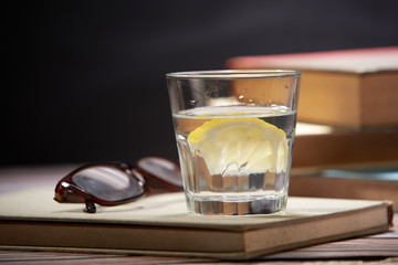 still of lemon water with book and glasses