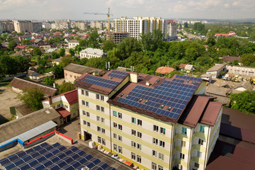 Obraz premium Aerial view of many solar panels mounted of industrial building roof.