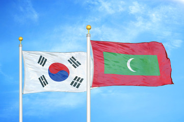 South Korea and Maldives two flags on flagpoles and blue cloudy sky