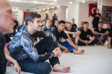 Group of student on martial arts seminar sits in dojo