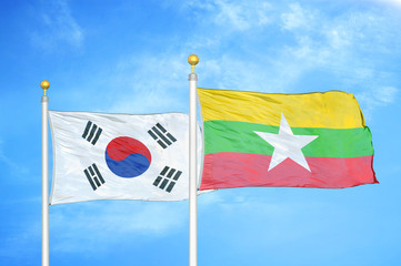 South Korea and Myanmar two flags on flagpoles and blue cloudy sky