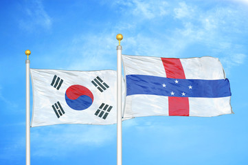 South Korea and Netherlands Antilles two flags on flagpoles and blue cloudy sky