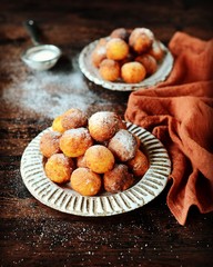 Cottage cheese donuts in a ceramic dish on a dark wooden table