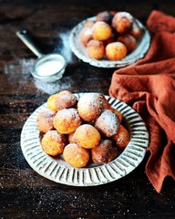 Cottage cheese donuts in a ceramic dish on a dark wooden table