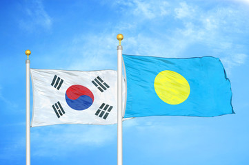 Naklejka premium South Korea and Palau two flags on flagpoles and blue cloudy sky