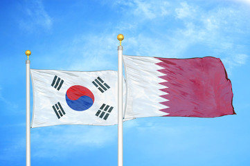 South Korea and Qatar two flags on flagpoles and blue cloudy sky