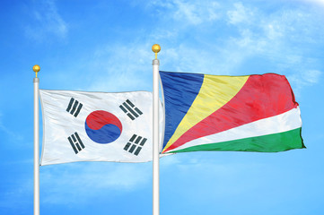 South Korea and Seychelles two flags on flagpoles and blue cloudy sky