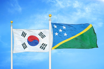 South Korea and Solomon Islands two flags on flagpoles and blue cloudy sky