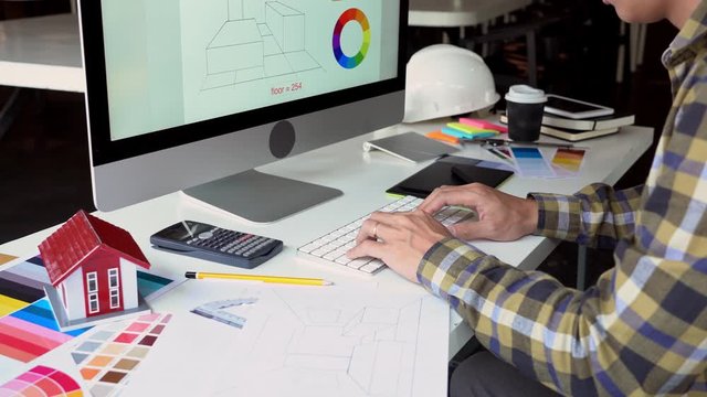 4k video of Interior designer or engineer hand working with equipment architects with modern computer on desk with sample material board and Planning Blueprint.