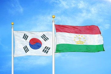 South Korea and Tajikistan two flags on flagpoles and blue cloudy sky